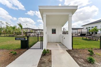 A white dog park pavilion with a black fence and gate.